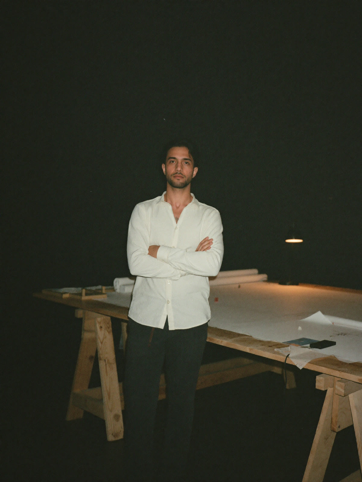 Ali Al-Khafaji standing at the studio worktable